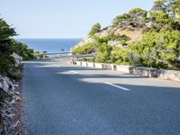 the road goes around the mountain to the sea and the green trees on the cliff