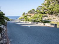 the road goes around the mountain to the sea and the green trees on the cliff