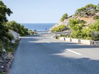the road goes around the mountain to the sea and the green trees on the cliff