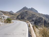 a mountain road winding through the mountains into the distance, with the mountains surrounding it