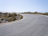 the curved road that is going to the mountain top with no traffic signs on it