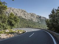 there is a large mountain with a road in the middle of it and a motorcycle that has been parked on the side of the street