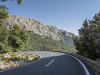 there is a large mountain with a road in the middle of it and a motorcycle that has been parked on the side of the street