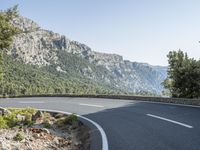 there is a large mountain with a road in the middle of it and a motorcycle that has been parked on the side of the street