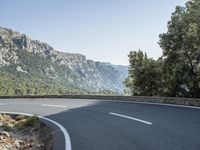 there is a large mountain with a road in the middle of it and a motorcycle that has been parked on the side of the street