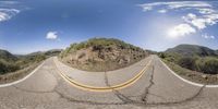 a view from inside a fish eye lens of an empty road and a mountain side