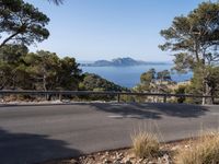 the road that leads to some mountains near the ocean in greece - a road along the coast with view over the sea