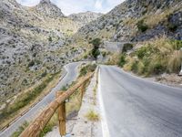 the road winding up to the mountain with the stone walls of a tunnel on either side