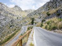 the road winding up to the mountain with the stone walls of a tunnel on either side