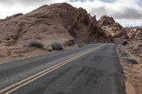 two lines are visible on the asphalt of an empty desert road and it appears to be steep