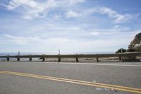 the road is very scenic by the ocean, and has an ocean and blue sky