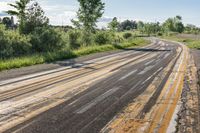 a empty road surrounded by trees in an open grassy area near the waterline,