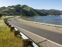 a scenic road along a large body of water with a mountain in the background in rural western nevada