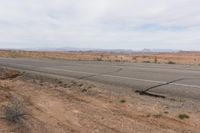 the road stretches along the dry desert area for vehicles to travel through the valley on