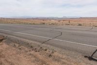 the road stretches along the dry desert area for vehicles to travel through the valley on