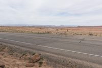 the road stretches along the dry desert area for vehicles to travel through the valley on