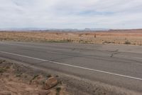 the road stretches along the dry desert area for vehicles to travel through the valley on