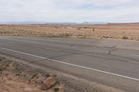 the road stretches along the dry desert area for vehicles to travel through the valley on