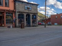 a red fire hydrant sitting in front of an old store window and building next to an open air field