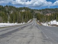 A Scenic Road Leading to Snowy Mountains and a Lake