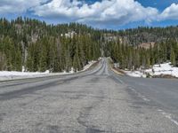 A Scenic Road Leading to Snowy Mountains and a Lake