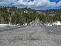 A Scenic Road Leading to Snowy Mountains and a Lake