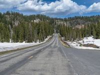 A Scenic Road Leading to Snowy Mountains and a Lake