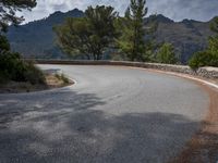 the top of an empty mountain is shown with a curve in the road that goes over it