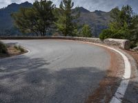 the top of an empty mountain is shown with a curve in the road that goes over it