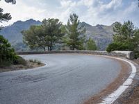 the top of an empty mountain is shown with a curve in the road that goes over it