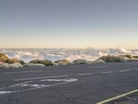 this is a scenic road with an air plane on the side in a cloud filled sky