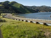 a person is standing by the edge of a highway and holding a bike helmet and poles