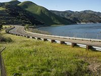 a person is standing by the edge of a highway and holding a bike helmet and poles