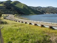 a person is standing by the edge of a highway and holding a bike helmet and poles