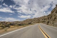 the view from a motorcycle is going down a desert road, as seen from a vehicle's side