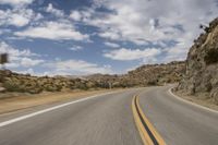 the view from a motorcycle is going down a desert road, as seen from a vehicle's side