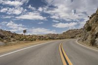 the view from a motorcycle is going down a desert road, as seen from a vehicle's side