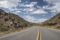 the view from a motorcycle is going down a desert road, as seen from a vehicle's side