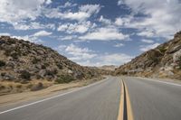 the view from a motorcycle is going down a desert road, as seen from a vehicle's side