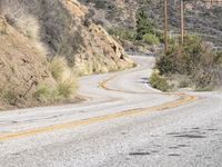 a view down the winding road at a stop sign that is pointed toward you in the direction