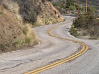 a view down the winding road at a stop sign that is pointed toward you in the direction