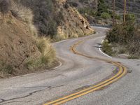 a view down the winding road at a stop sign that is pointed toward you in the direction