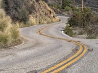 a view down the winding road at a stop sign that is pointed toward you in the direction