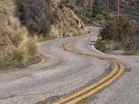 a view down the winding road at a stop sign that is pointed toward you in the direction