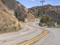 a view down the winding road at a stop sign that is pointed toward you in the direction