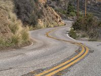 a view down the winding road at a stop sign that is pointed toward you in the direction