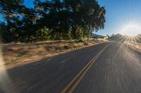 the image is from inside of a car going down the road in the sun rays