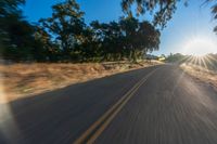 the image is from inside of a car going down the road in the sun rays