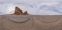 two people with a helmet, skateboards and a dog are in a desert view