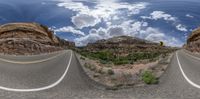 this is a panoramic view of an empty road that winds through the desert